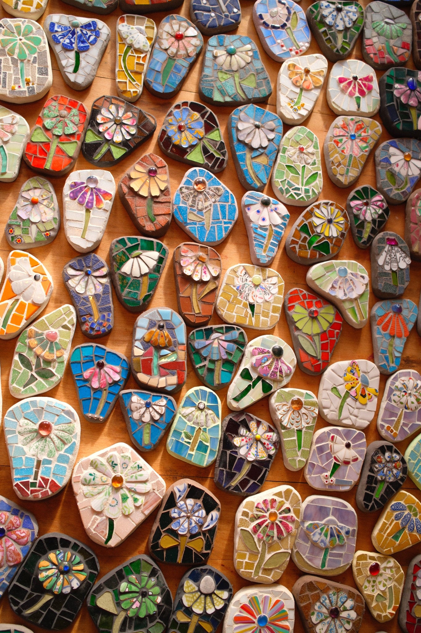 Collection of colourful mosaic flowers on a wooden surface
