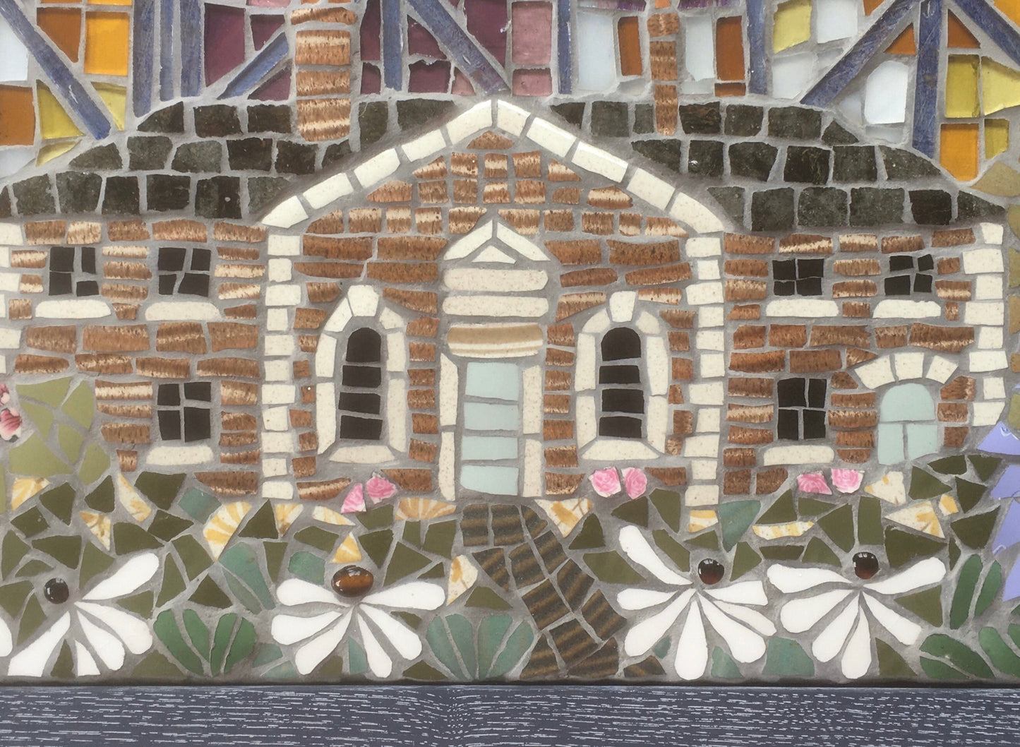mosaic of a cottage made in mosaic, with daisies and colourful background