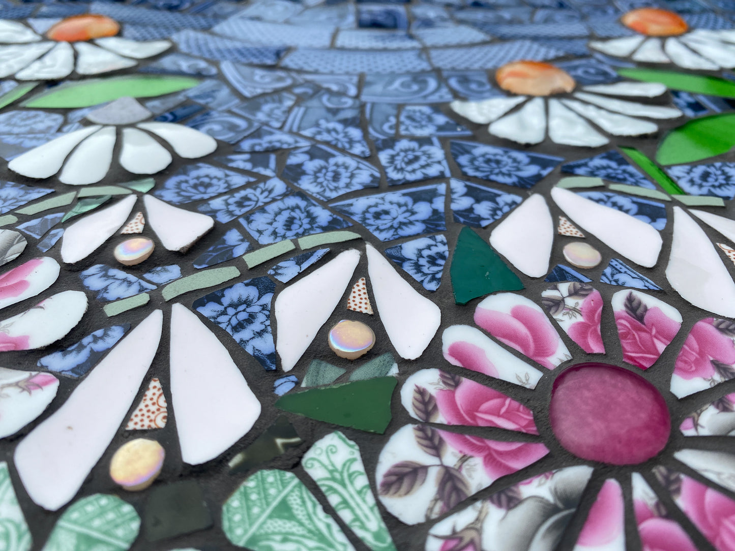 Mosaic artwork with flowers and patterns in various colours