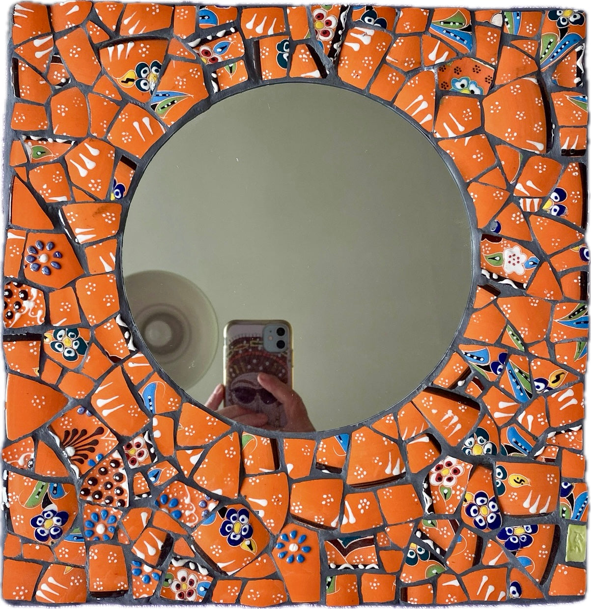 Bright orange mosaic mirror made from Turkish pottery. Square in shape with a circular mirror