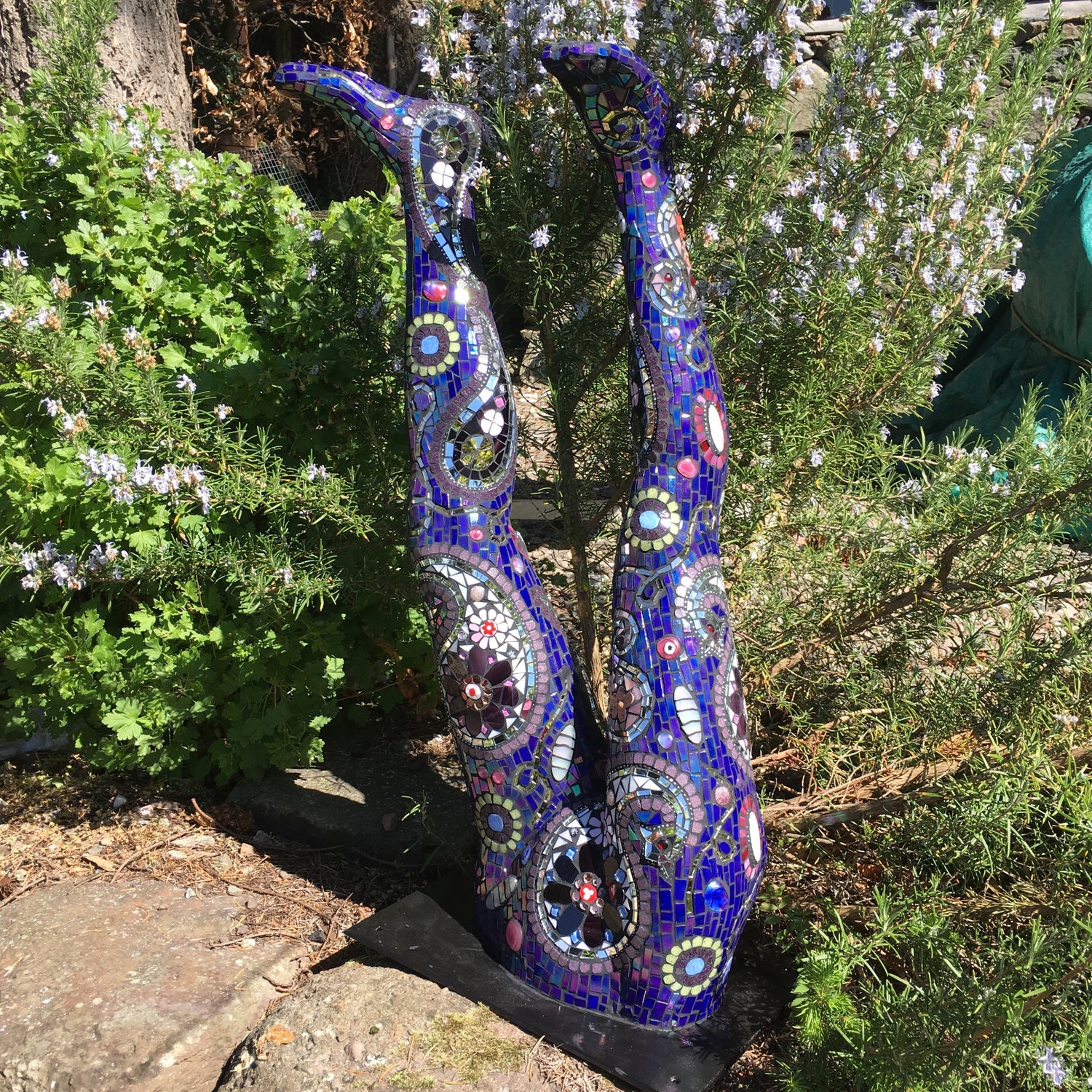 a pair of legs sticking up from a wall, rendered in a purple mosaic with a paisley design over