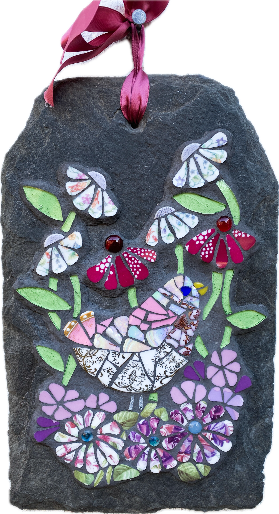 mosaic on slate of a pink gold and white bird surrounded by mosaic flowers in pink, hot pink and chintz tones. leaves in pale green glass. on a white background