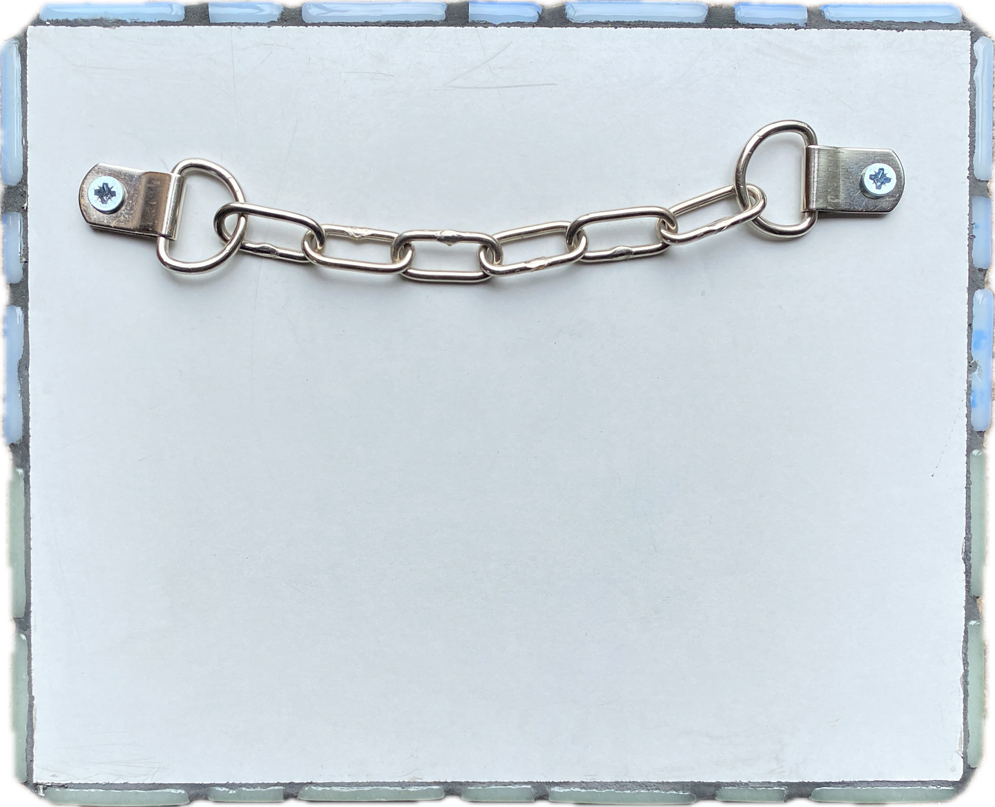 reverse sided of the mosaic, showing the white laminated side, with D rings and chain fixing