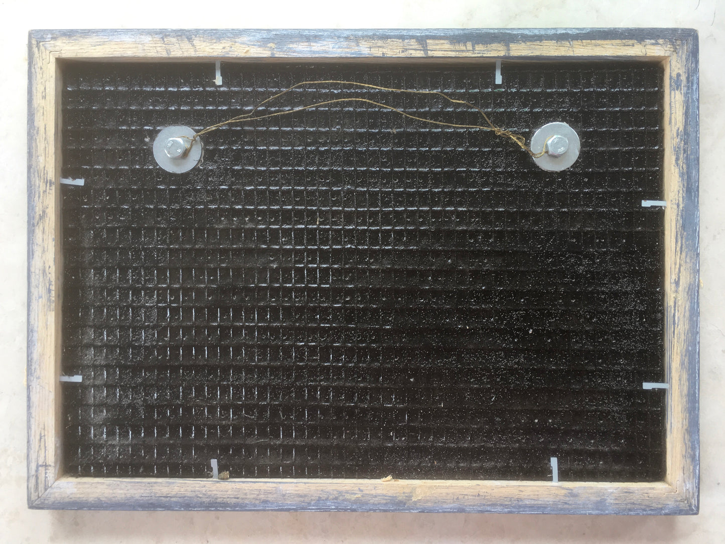 the reverse of a picture showing black board and wire fixing