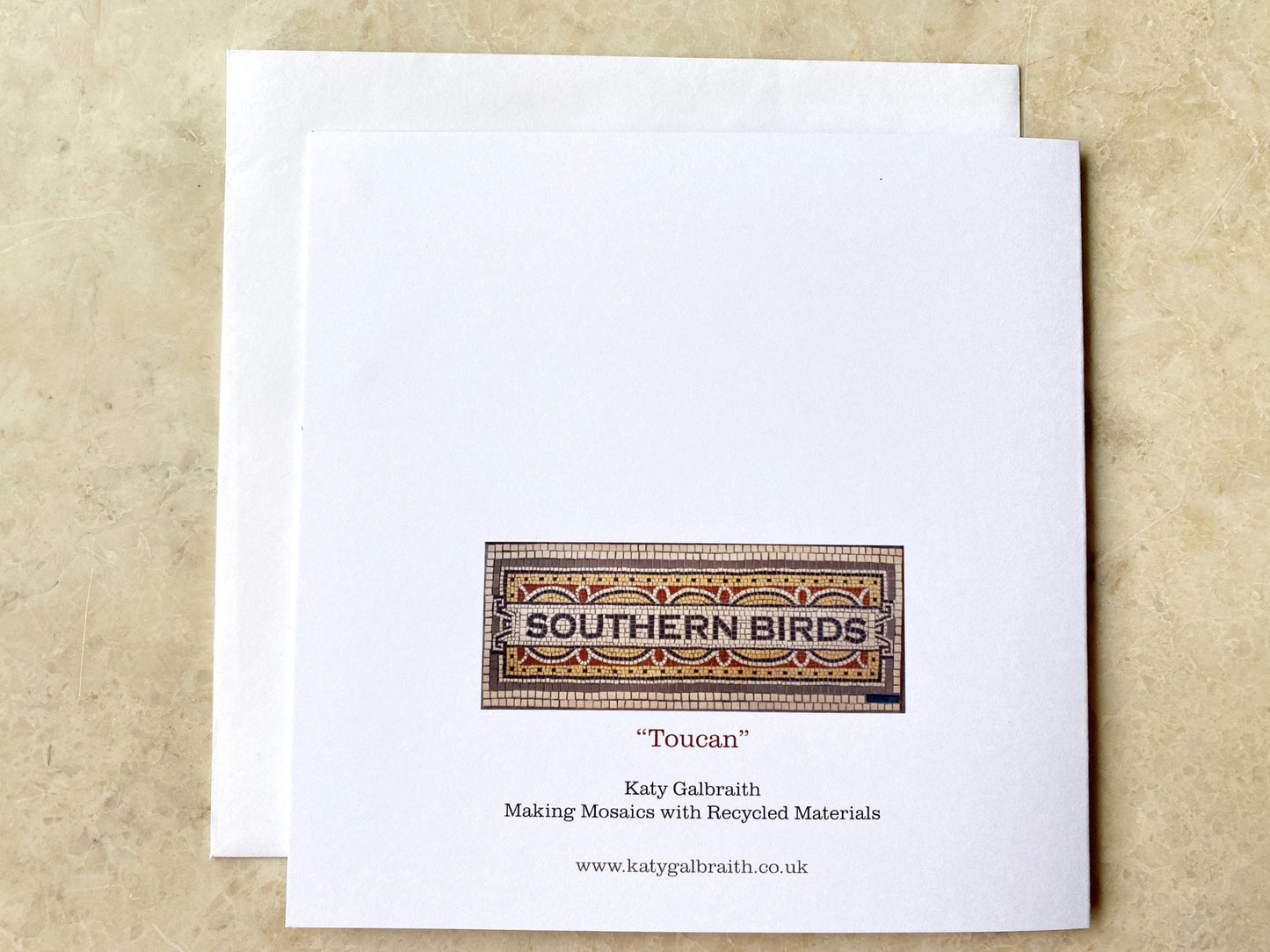 The reverse of the card, which has an image of the mosaic with text "Southern Birds" surrounded by traditional mosaic and the "Toucan" card title. Photographed on a neutral background