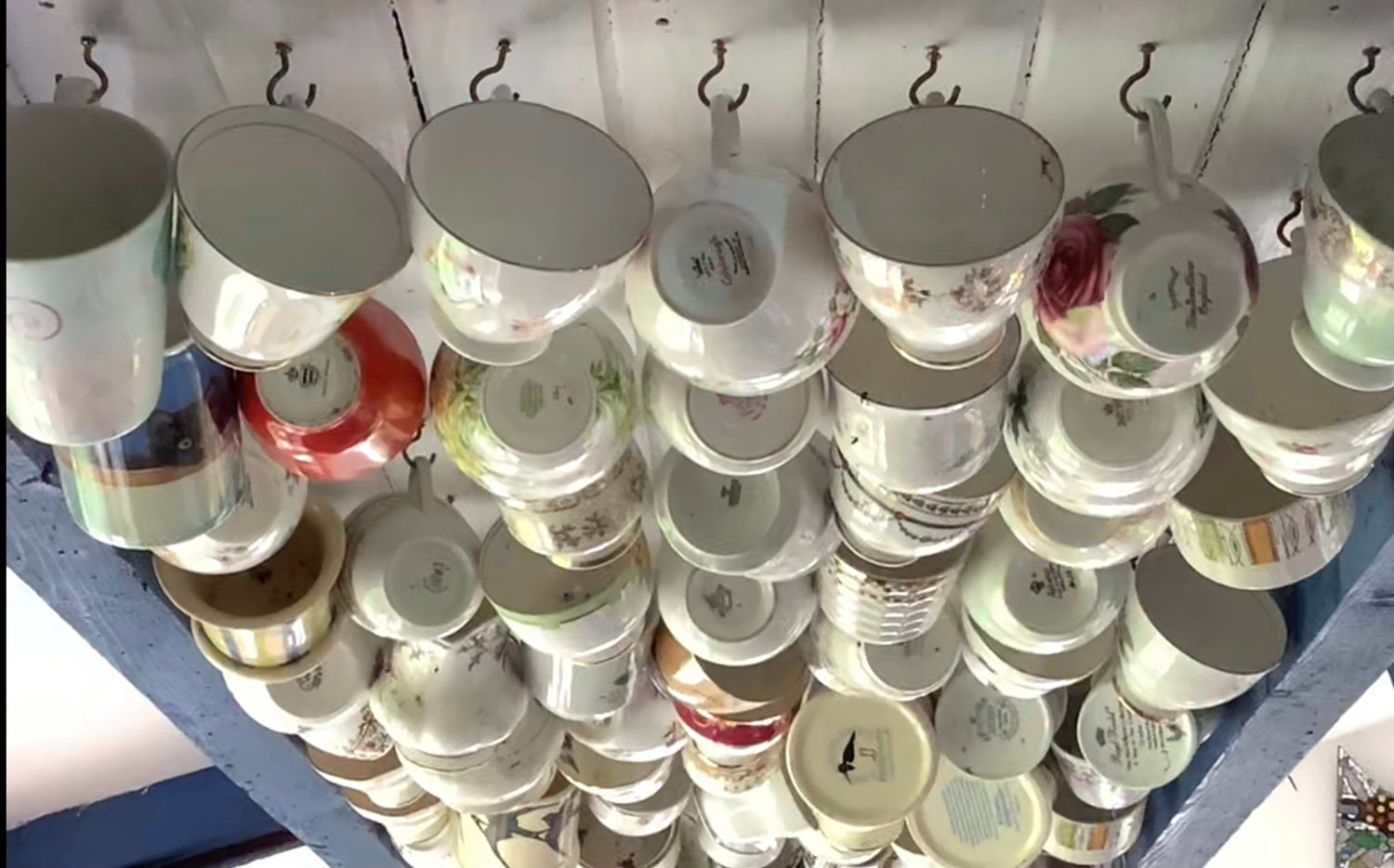 tea cups and mugs hanging from a panel