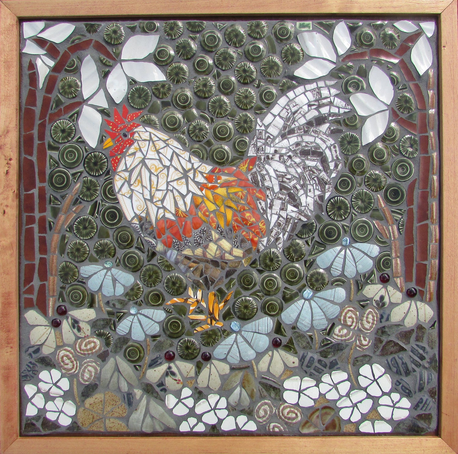 a rooster in a flower garden made from recycled crockery. The background is green textured circles