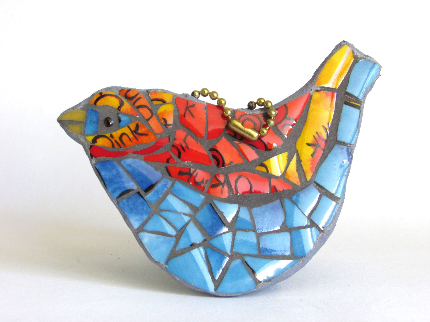 a blue and red bird made in mosaic from a bone china mug