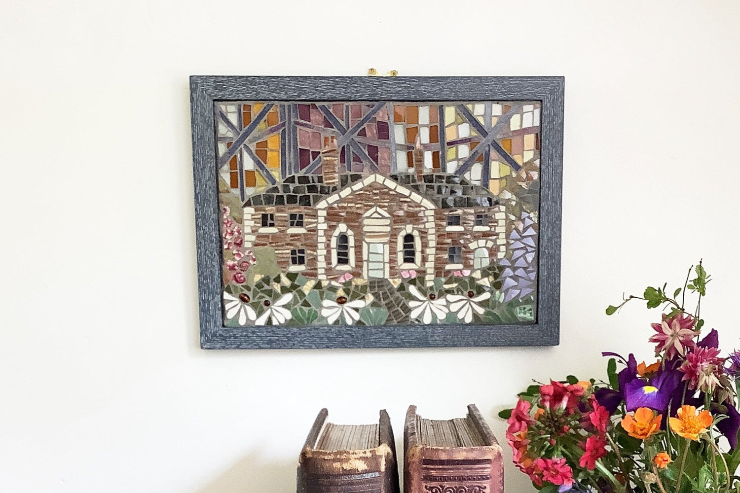 mosaic of a cottage with a flower garden and the background is representing the reflective nature of a modern high rise building