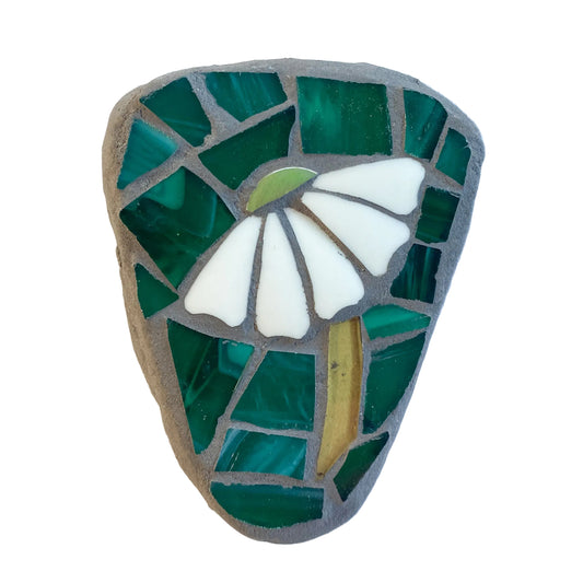 Mosaic art piece with a white flower design on a green background
