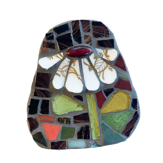 Mosaic art piece with a white and gilt flower design on a dark background