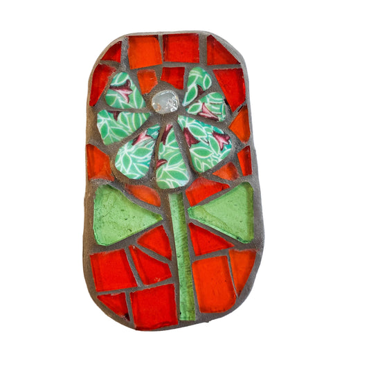 Mosaic art piece with orange and green colors on a white background