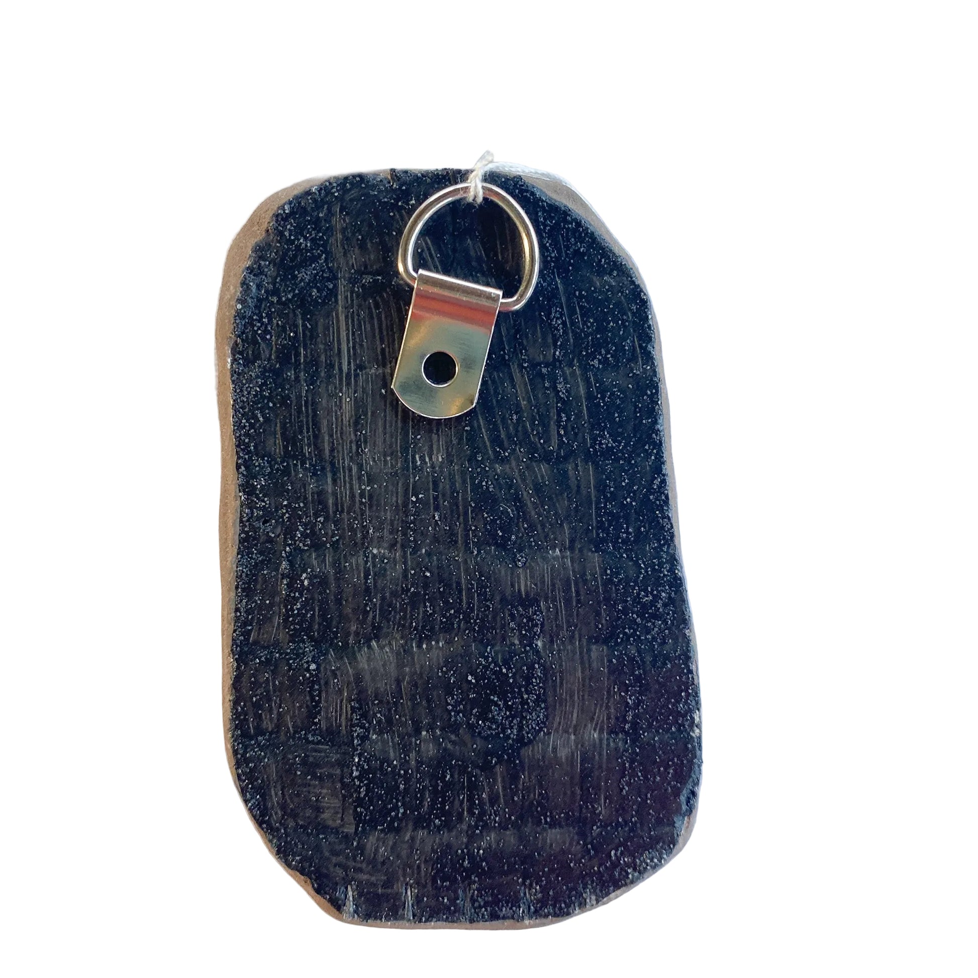 Black reverse side of a mosaic with a metal D-ring on a white background