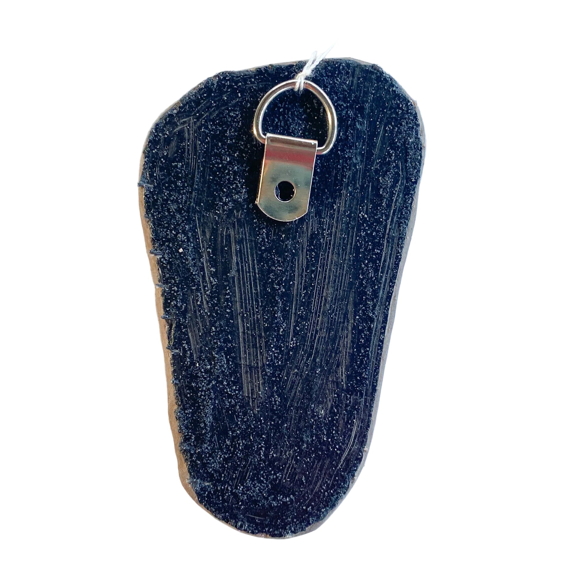 Black reverse side of a mosaic with a metal D-ring on a white background