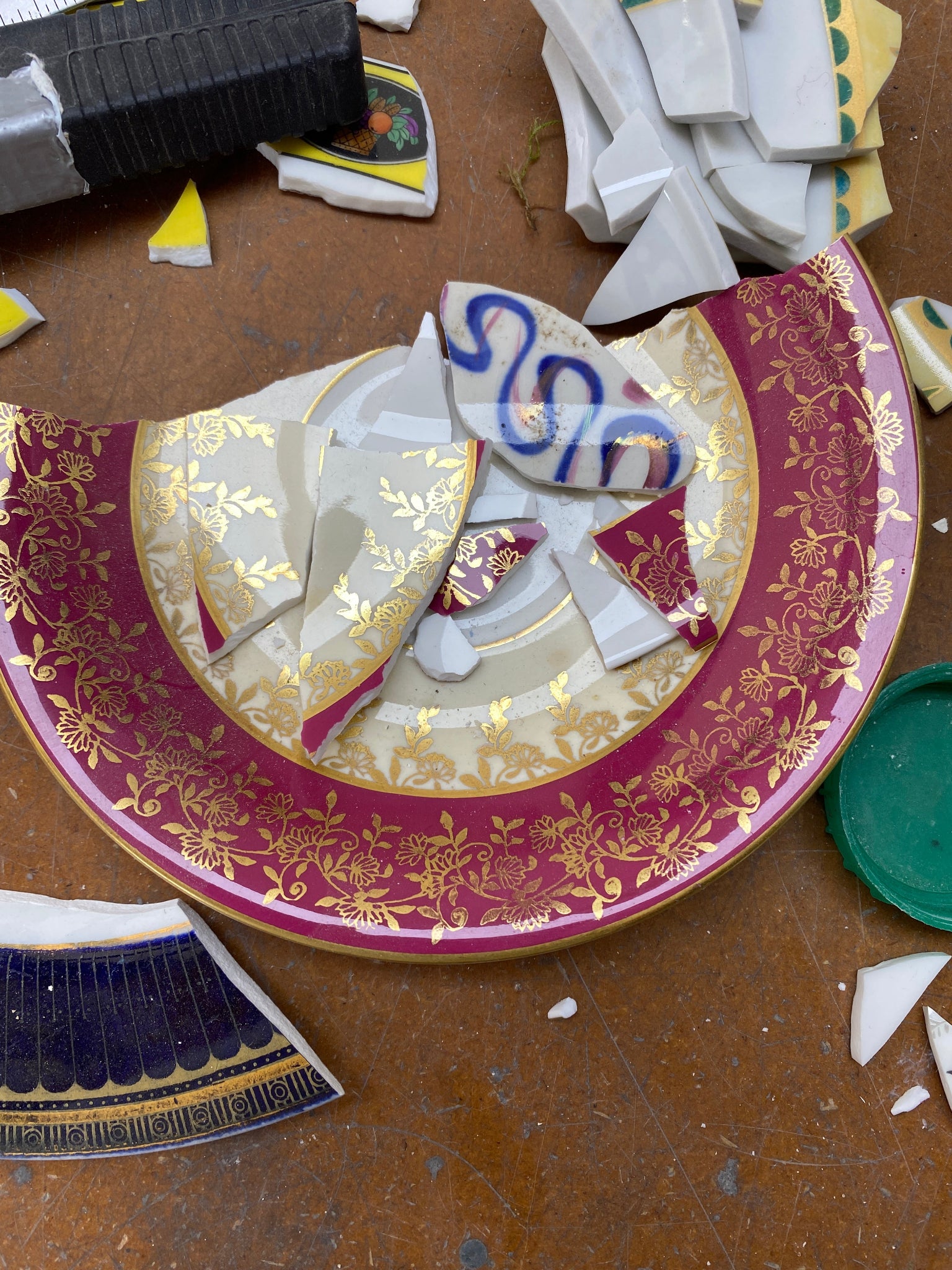 Broken ceramic plate with decorative edge on a brown surface