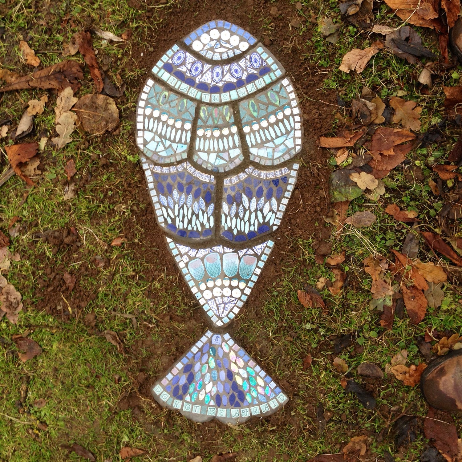 a fish stepping stone mosaic, composed of nine sections in blues and turquoise