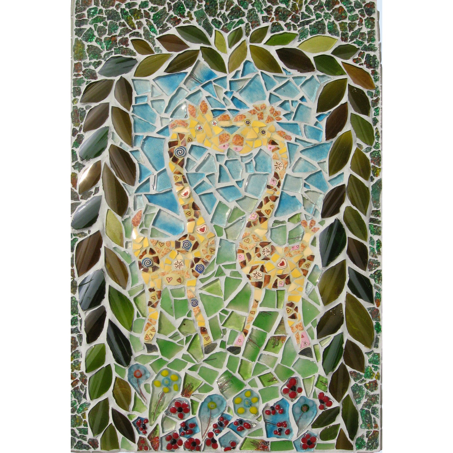 two yellow giraffes standing face to face, as if they are kissing.  Bordered by green leaves and a blue sky, green grass background.  All in mosaic