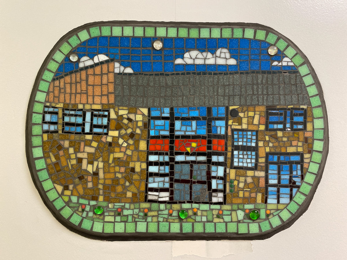 Mosaic artwork of a building with a blue sky and clouds on a beige background