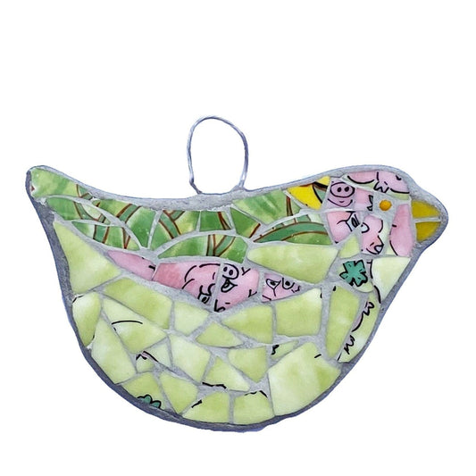 hanging bird mosaic mostly in green bone china, with pink areas showing pigs noses and feet. on a white background