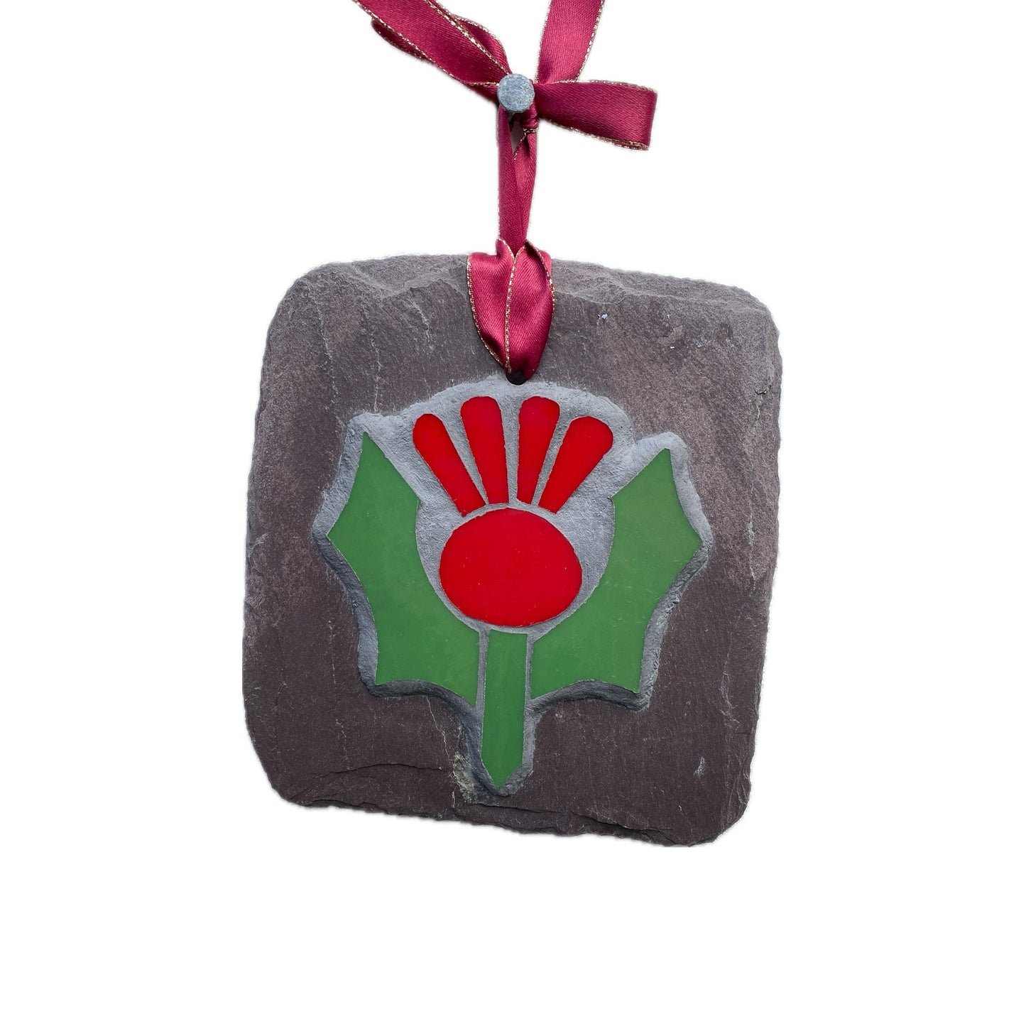 Red and green thistle in mosaic on a grey slate. Shown on a white background