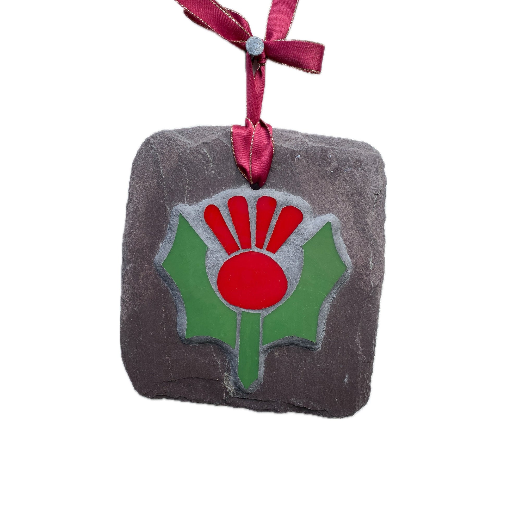 Red and green thistle in mosaic on a grey slate. Shown on a white background