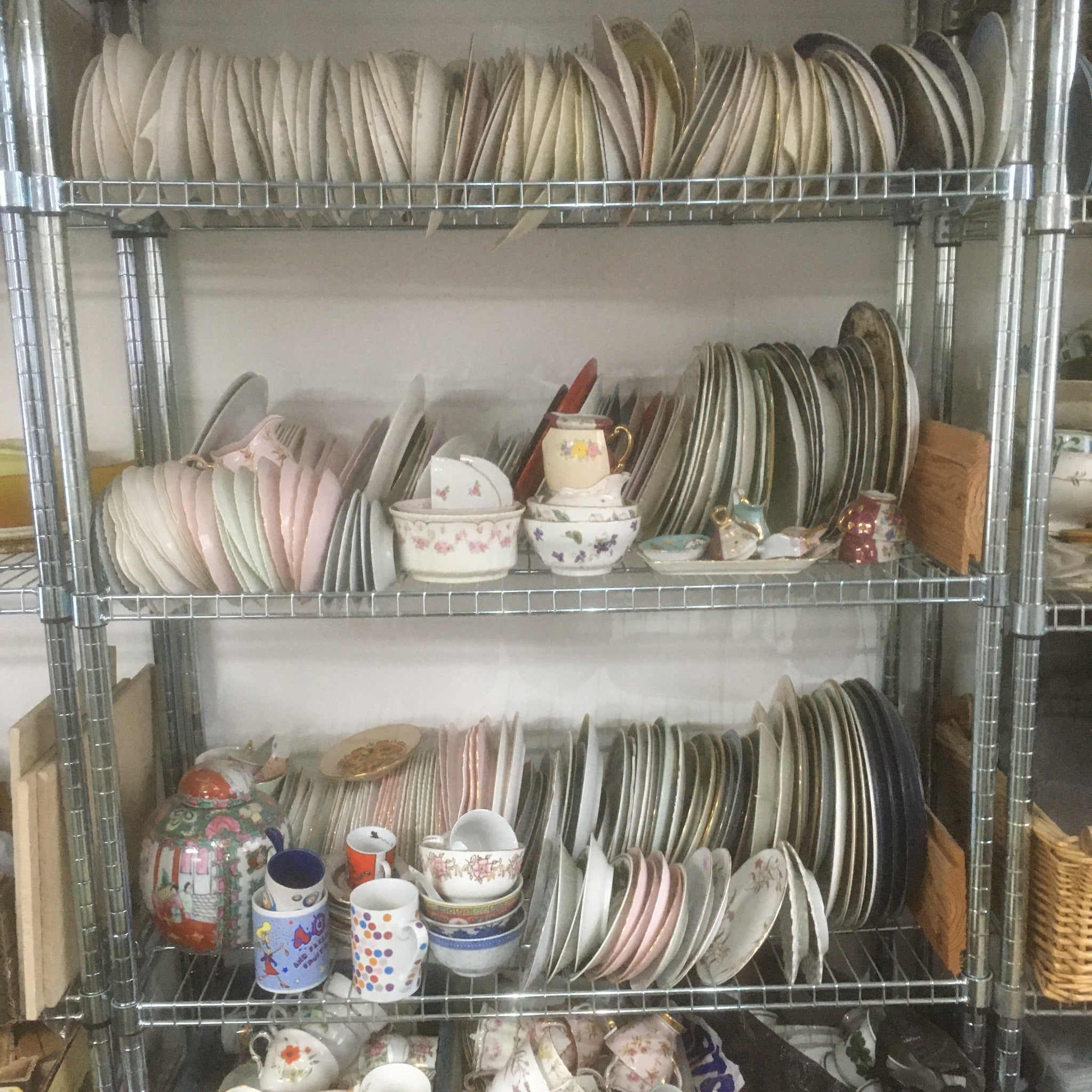 a metal shelving using with bone china crockery on it