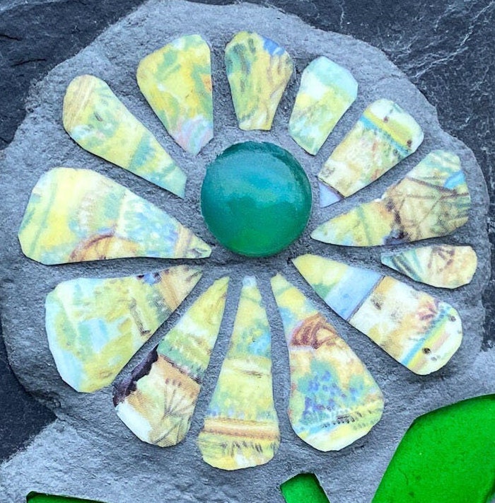 Mosaic flower with yellow patterned petals with a landscape design on them