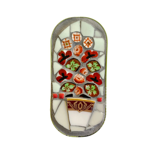 Mosaic art piece in an anchovy tin with floral design on a  white background