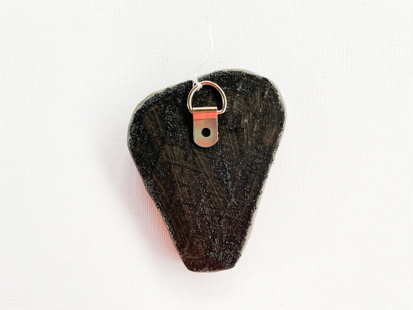 textured reverse side of mosaic with d-ring on a white background