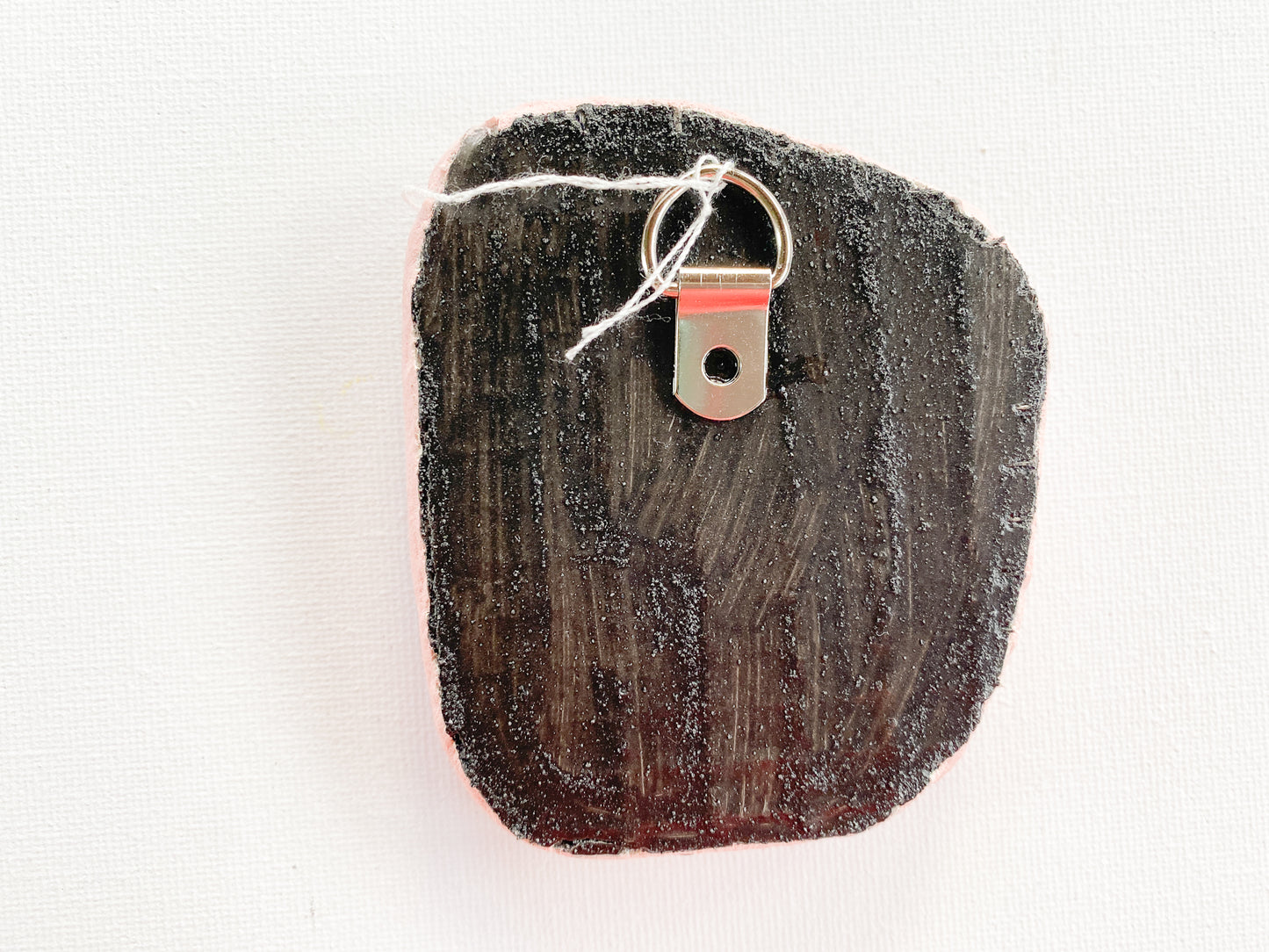 textured reverse side of mosaic with d-ring on a white background