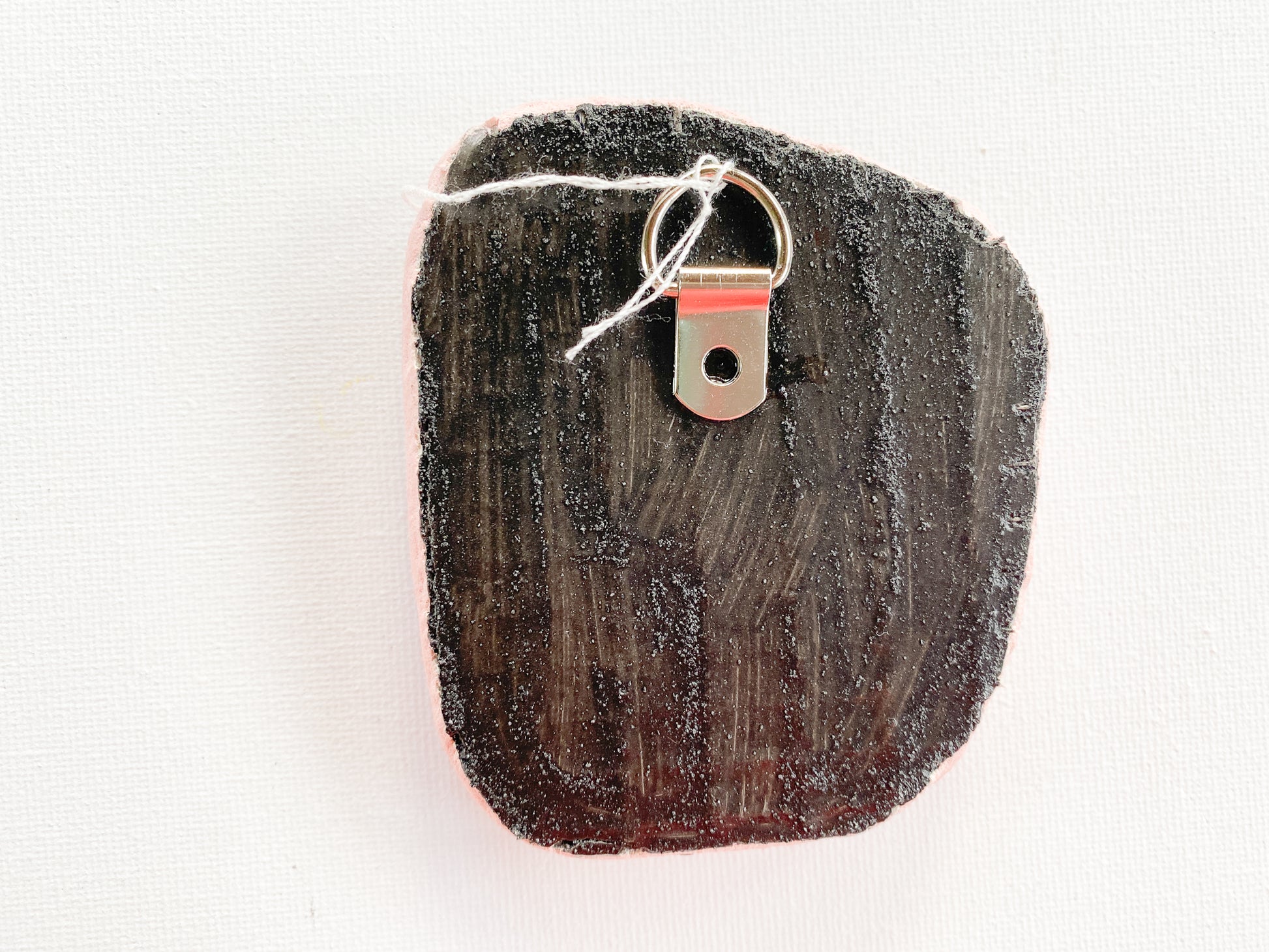 textured reverse side of mosaic with d-ring on a white background