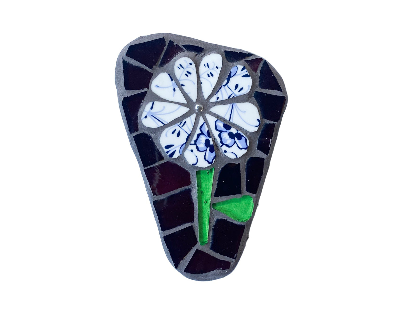 Mosaic art piece of a flower on a dark background, photographed on white