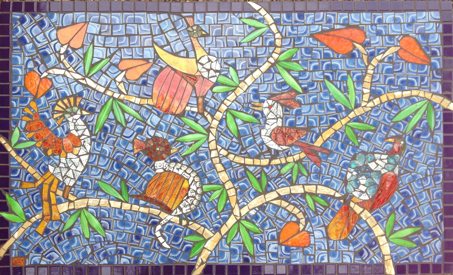 colourful mosaic tabletop with imaginary exotic birds on a blue background