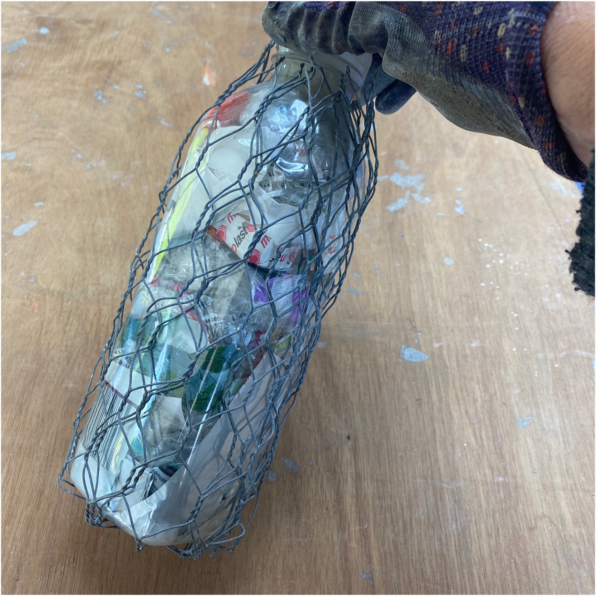 a plastic bottle, filled with plastic and encased with chicken wire