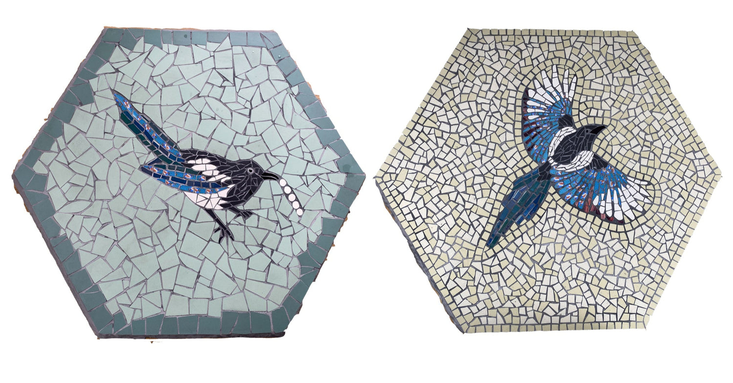 two hexagonal paving slabs with mosaics of magpies on them