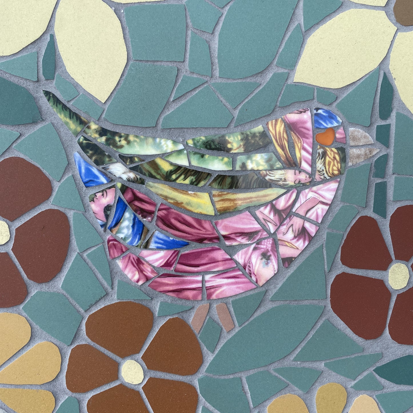 A colorful mosaic bird design made from reflective bone china tiles, surrounded by matching floral and leaf shapes in teal, brown, cream, and pink.