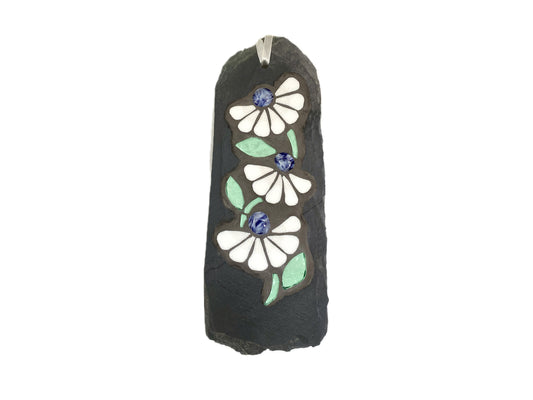 Decorative mosaic on slate with a floral design photographed on a white background