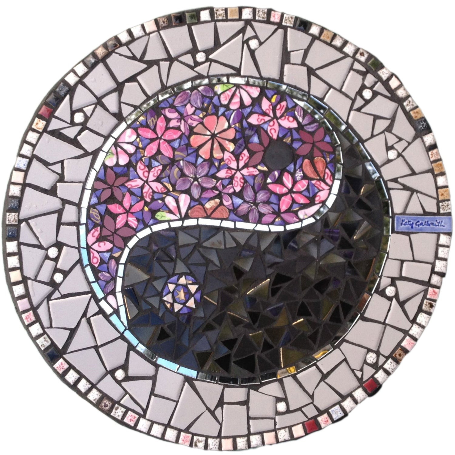 ying yang symbol in mosaic, with one section in pink flowers, the other in black triangles